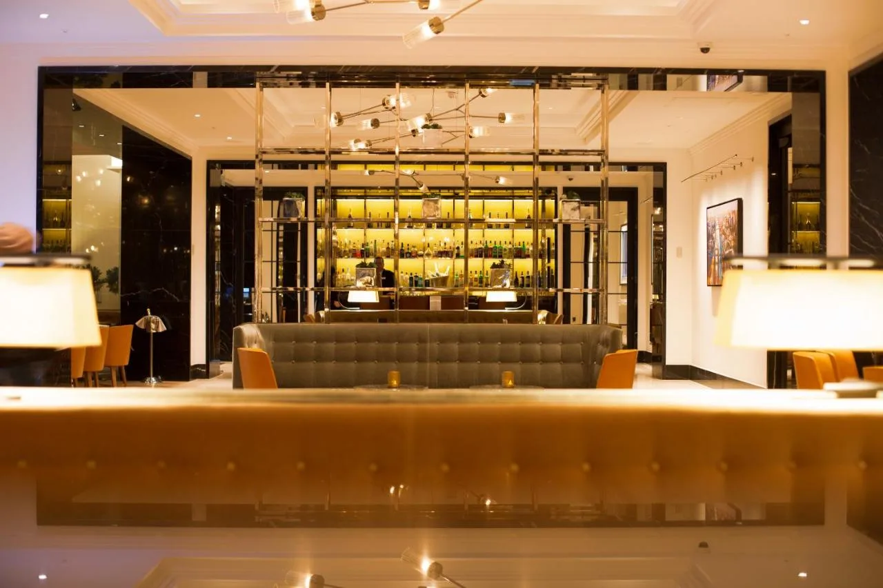 a hotel lobby with a couch and a bar at Blakemore Hyde Park in London