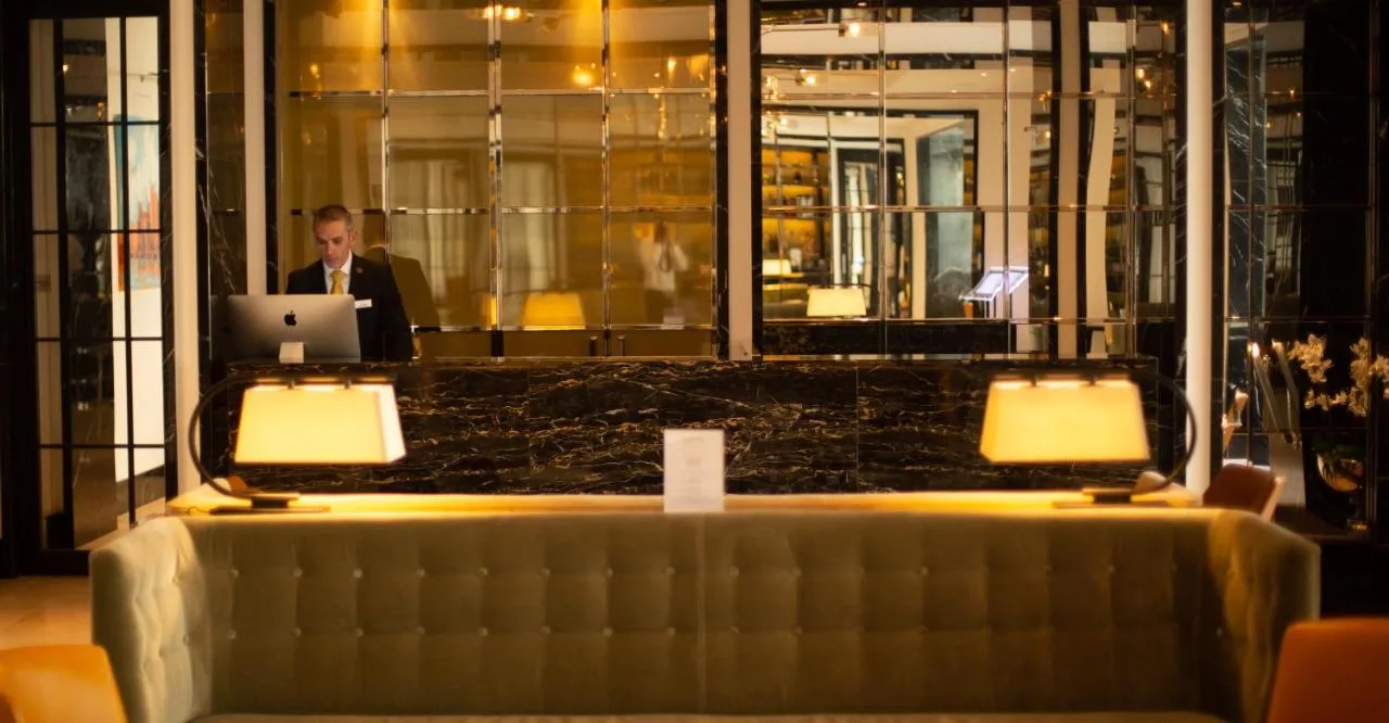 a man working on a laptop computer in a restaurant at Blakemore Hyde Park in London